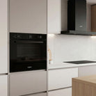 Whirlpool W3OMK35HR0BA black oven installed in a kitchen