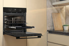 Whirlpool W4OMK581HU1BAUS black oven with door open in a kitchen setting