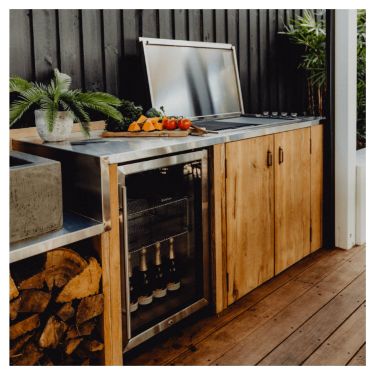 Artusi outdoor beverage chiller built into a timber outdoor kitchen beside a BBQ